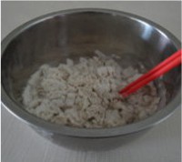 苦荞猫耳朵做法步骤：用筷子把面粉和冷水搅拌均匀，形成雪花状的面絮
