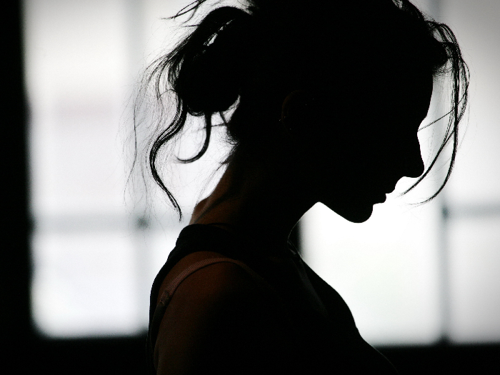 Silhouette of a woman's head with waving hair in a bun