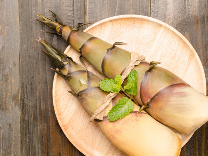 Fresh bamboo shoots served on a wooden plate on a wooden table