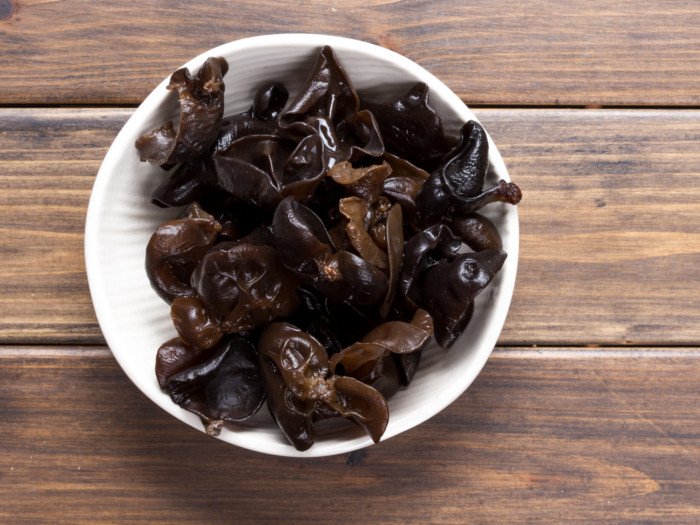 Black fungus in a white bowl on a wooden table