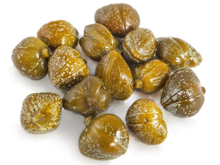 A couple of capers spread on a white background