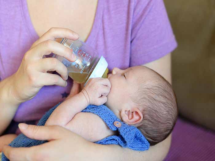 A woman feeding her baby with bottle