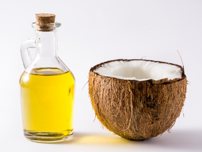 A bottle of oil and half a coconut