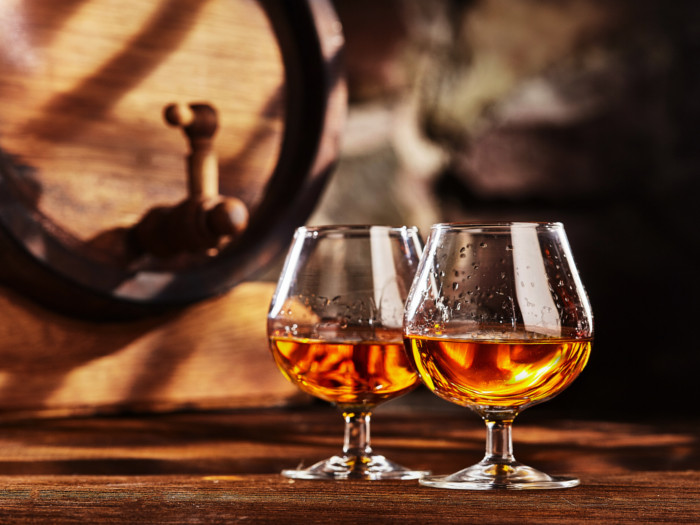 Cognac served in two glasses on a counter in a distillery
