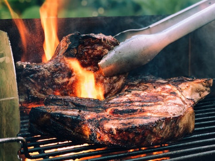 Cooking beef on a barbeque outdoors