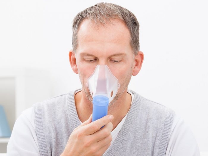 A man trying to breathe through the oxygen mask