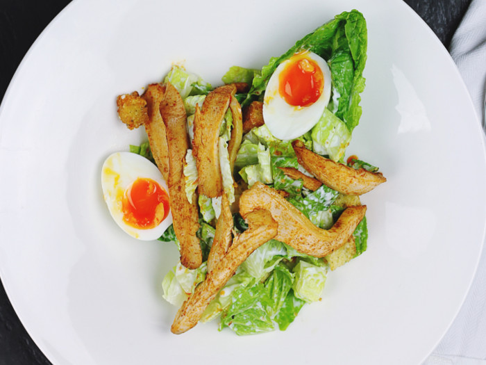 A low carb meal of chicken served on lettuce leaves with half-cut eggs