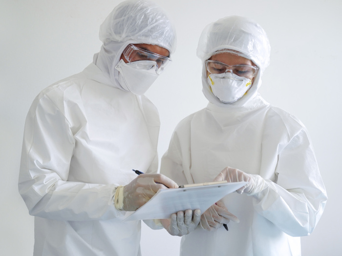 Doctor and nurse wearing PPE, checking reports