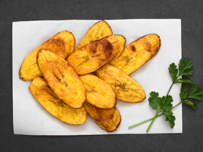 Plantain chips on a parchment paper garnished with cilantro