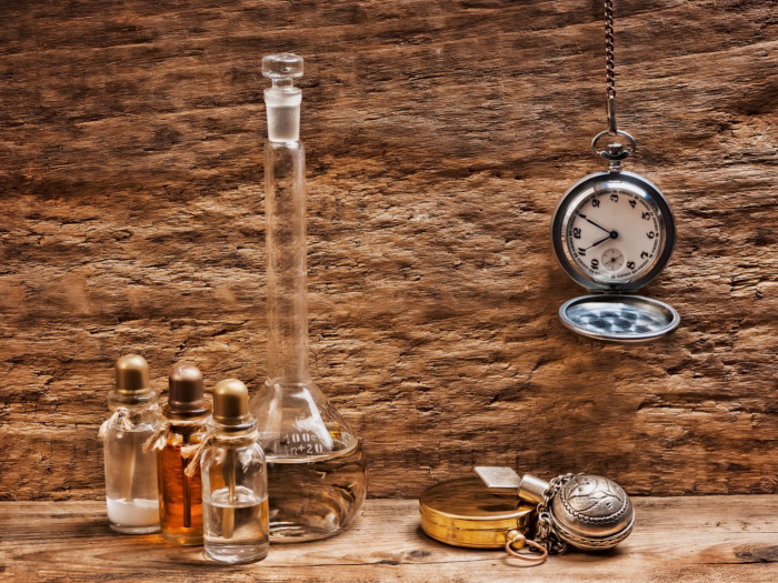 Bottles of rosewood oil with a tall flask and vintage clock hanging