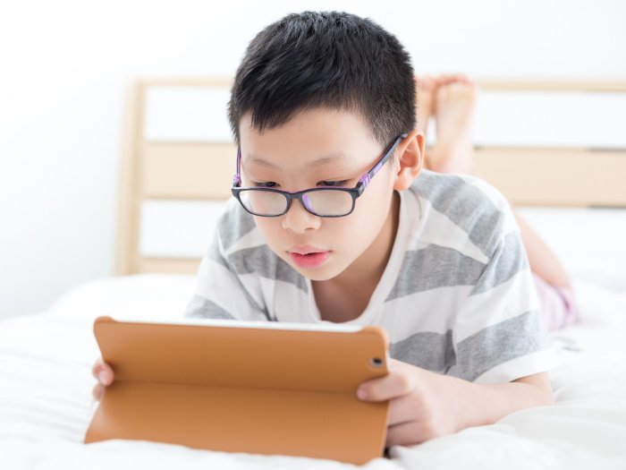 A young boy playing games on his tablet