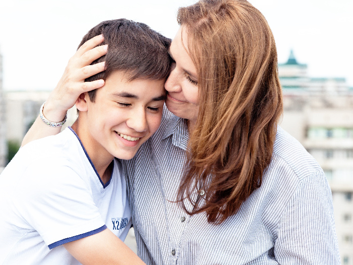 A teenage boy hugging his mother