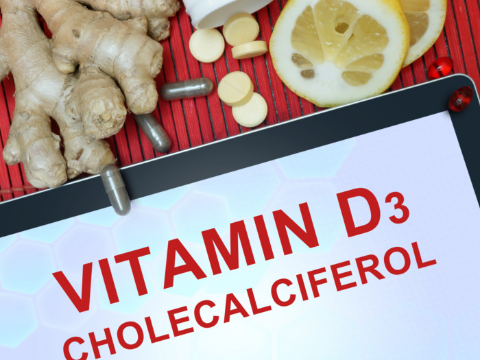 Vitamin D3 written on a screen with ginger, tablets, and lemon on the top